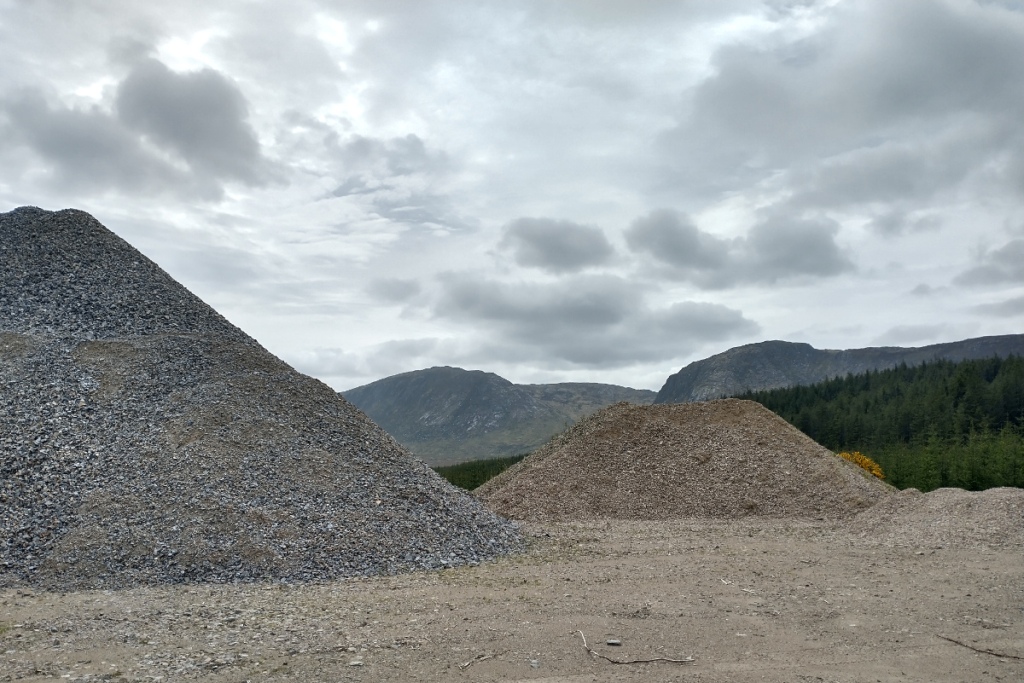 photograph of large heaps of stone to be used to build and repair forestry tracks with The Dungeon Hills in the background