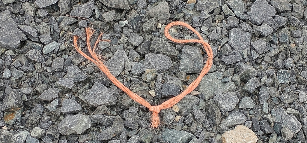 photograph of a knotted loop of orange twine found on the forestry track